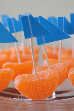 small candies with blue flags on them are arranged in the shape of heart - shaped lollipops