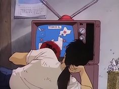 a woman sitting in front of a tv with her hand on her face and looking at the screen