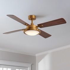 a ceiling fan that is hanging from the ceiling in a room with white walls and windows