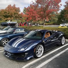 two blue sports cars parked in a parking lot