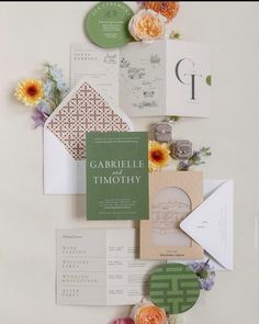 the wedding stationery is laid out on top of each other with flowers and cards