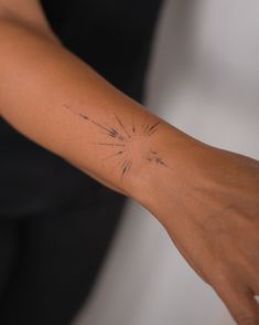 a woman's arm with an arrow tattoo on the left side of her arm