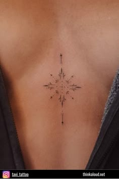 a cross tattoo on the back of a woman's stomach