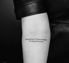 a black and white photo of a person's arm with a quote on it