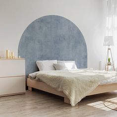 a bedroom with white walls and wooden floors