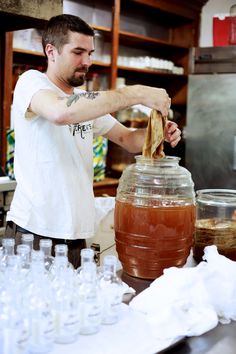 a man is making something in a large jar