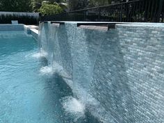 the water is running down the side of the wall by the pool and there are no people in it