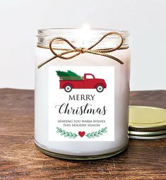 a christmas candle with a tag on it sitting next to a jar filled with candles