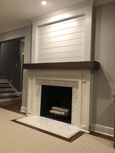 an empty living room with a fireplace and stairs