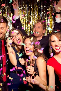 a group of people standing next to each other with confetti in front of them