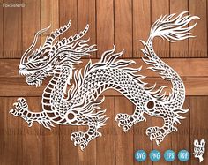 a paper cutout of a dragon on a wooden background