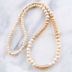 With a mix of whitewash and gold wood beads and in an easy pull-over-the-head style, this limited edition wood bead necklace is sure to dress up...well, anything! 8mm whitewashed and gold painted wooden beads gold-plated crimp with bead closure 28 inches long all Libby & Smee necklaces come packaged in a clear resealing bag for storage Wood Bead Necklace Boho, Adjustable Gold Beaded Necklaces With Wooden Beads, Adjustable Gold Beaded Necklace With Wooden Beads, Gold Beaded Necklaces With Wooden Beads, Adjustable Gold Necklace With Wooden Beads, Gold Beaded Necklace With Wooden Beads, Everyday Beige Jewelry With Wooden Beads, Gold Long Beaded Necklaces With Wooden Beads, Gold Long Beaded Necklace With Wooden Beads