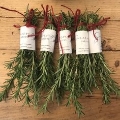 three rosemary bundles tied together with twine and twine string on top of a wooden table