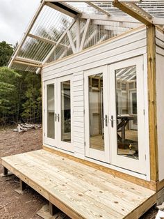 a small white house with glass doors and windows