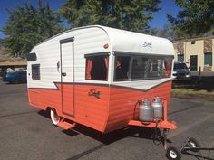 an orange and white trailer parked in a parking lot