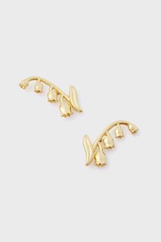 two pairs of gold earrings with leaves on the side and one earring in the middle