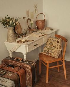 two pieces of luggage sitting on top of a wooden floor next to a white desk