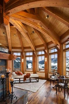 a living room filled with lots of furniture and large windows next to a fire place