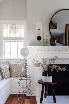 a living room filled with furniture and a fire place in front of a mirror on the wall