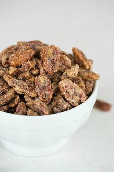 a white bowl filled with nuts on top of a table