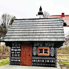 a small black and white house with a wooden door