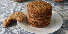 a stack of oatmeal cookies sitting on top of a white plate next to a cooling rack