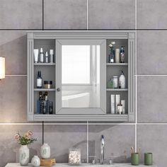 a bathroom sink with a medicine cabinet above it and a mirror on the wall next to it