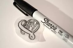 two hearts drawn on a piece of paper next to a marker with the word love