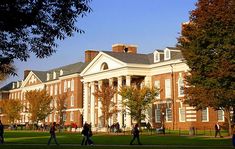 people walking on the grass in front of a building