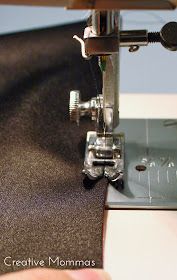 someone is using a sewing machine to sew something on the side of a piece of fabric