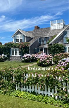 a large house with flowers growing on the fence