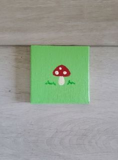 a small green painting with a mushroom on it