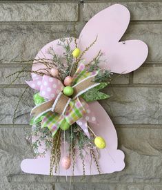 a pink bunny door hanger with eggs and greenery in the shape of a heart