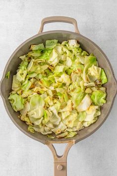 a pan filled with lettuce sitting on top of a counter next to a spatula