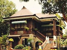 a large house with stairs leading up to the second story and flowers on the steps