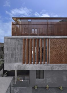 an architecturally designed concrete building with wooden balconies on the top and sides