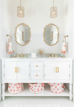 a bathroom with two sinks and mirrors on the wall next to it is decorated in pink polka dot pom poms