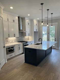 a large kitchen with white cabinets and an island in the middle of the room is shown