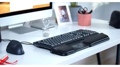 a computer keyboard sitting on top of a white desk