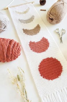 crocheted table runner with balls of yarn next to it and knitting needles on the side