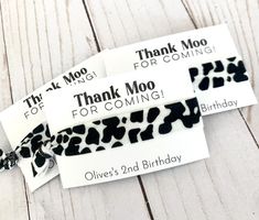 two thank you for coming birthday tags with black and white cow print ribbon on them