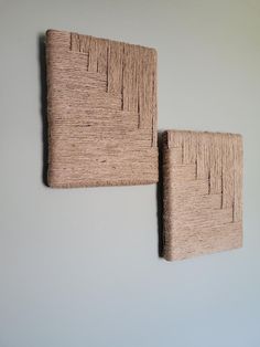 two woven wall hangings mounted to the side of a wall