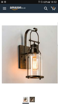 an old fashioned wall light with a glass shade on the front and side panels, attached to a white wall