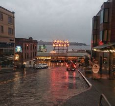 cars are driving down the street in the rain