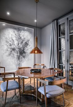 a dining room table with chairs and a painting on the wall