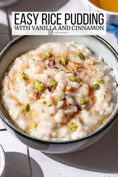 a bowl of rice pudding with pistachio and cinnamon on the side, next to a glass of orange juice