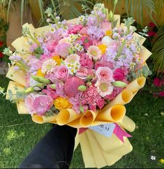 a bouquet of flowers is being held in someone's hand on the grass outside