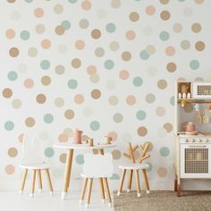 a child's playroom with polka dot wallpaper and wooden chairs in front of it