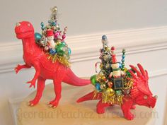 two red plastic dinosaurs with christmas decorations on them