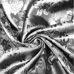 black and white photograph of an upholstered fabric with floral designs on it,